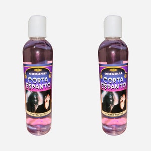 May include: Two bottles of a pink liquid with white caps. Each bottle has a label with the words "Original Corta Espanto" and an image of a scary face. The bottom of the label reads "Contra Sustos".