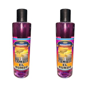 May include: Two bottles of purple liquid with a yellow and pink label that reads "ORIGINAL CAMBIA EL RUMBO".
