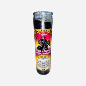 May include: A black glass candle with a pink and purple label. The label features a black and white illustration of a man on horseback holding a scythe. The text on the label reads "VELADORA Original Antiguo y Milagroso Spiritu Dominador CITRUN NUEVE SON EL PODER QUE HACE QUE MI ESPIRITU DOMINANTE TE HA DADO HAZ QUE"