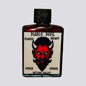 May include: A small glass bottle with a red liquid inside. The label reads "Diablo Devil" with the words "Dinero" and "Money" on either side of the label. The label also features a cartoon image of a red devil with horns and a beard. The words "Poder" and "Power" are below the image, and the words "Witches Valley" are at the bottom of the label.