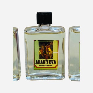 May include: A small, clear glass bottle with a black cap. The bottle has a label with a painting of two people and the text "ADAN Y EVA PRODUCTO ORIGINAL".
