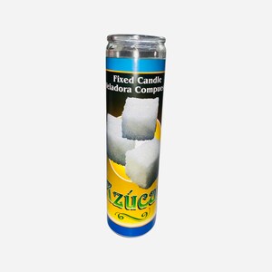 May include: A yellow and blue candle with a white label that says "Fixed Candle Veladora Compuesta" and has a picture of sugar cubes. The text "Azucar" is written in a decorative font on the label.