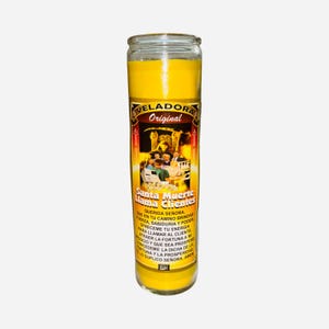 May include: A tall, cylindrical yellow candle in a glass jar. The label reads "VELADORA Original" and "Santa Muerte Llama Clientes" with additional Spanish text. The candle has a religious theme.