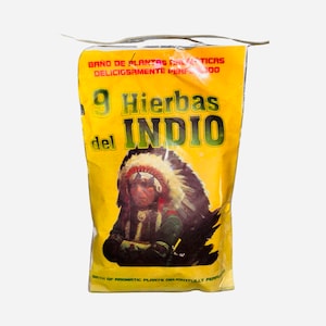 May include: A yellow package with a Native American illustration and the text "9 Hierbas del INDIO" in red and black. The text "BAÑO DE PLANTAS AROMATICAS DELICIOSAMENTE PERFUMADO" is in black. The package is for a bath of aromatic plants.