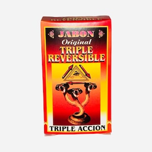 Könnte beinhalten: Eine rote und gelbe Schachtel mit dem Text "Jabon Original Triple Reversible" und "Triple Accion". Die Schachtel zeigt eine Grafik einer dreiköpfigen Schlange mit einem allsehenden Auge in einem Dreieck darüber.
