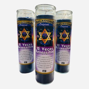 May include: Three glass candle jars with black wax and a purple label. The label has a star of David and the text "12 Veces Reversible" and "Veladora Original".
