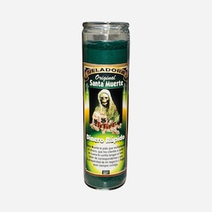 May include: A tall, green glass candle with a white wick. The candle has a label with the words "VELADORA Original Santa Muerte" and "Dinero Rápido" in Spanish. The label features an illustration of a skeleton.
