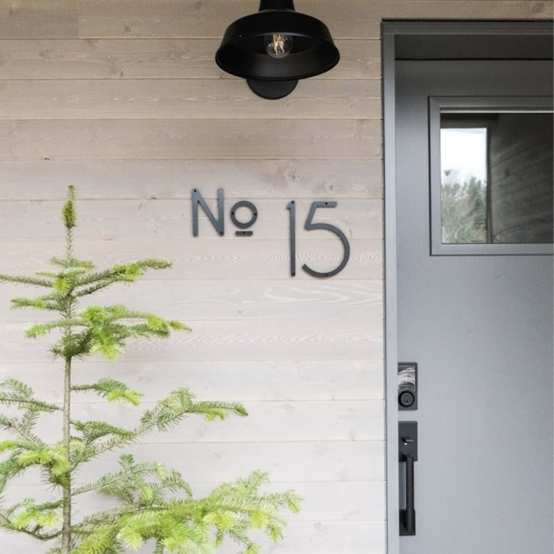 A modern house number sign with 5 inch THIN MODERN No letters and 8 inch numbers fastened with screws and spacers.