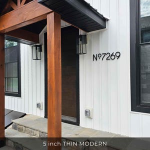 THIN MODERN 5 inch black address numbers on white siding beside a black front door