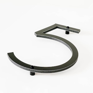 Close up detail of the THIN MODERN house number showing the black core of recycled plastic and aluminum edge only visible from the side.