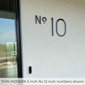 A modern front door number sign  with 5 inch THIN MODERN No letters and 12 inch number fastened with screws and spacers.
