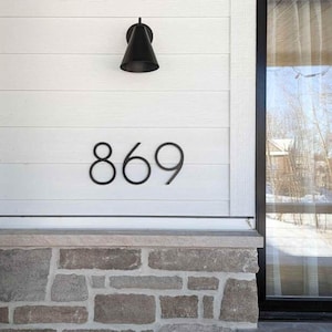 THIN MODERN 8 inch black address numbers 869 on white siding above stone facade