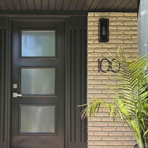 THIN MODERN 8 inch numbers 100 on brick beside a black front door
