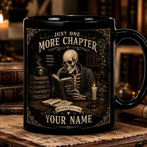 Puede incluir: Una taza de cerámica negra con el gráfico de un esqueleto leyendo un libro en un escritorio. El texto dice: JUST ONE MORE CHAPTER, BOOKS. COFFEE. ESCAPE., A THOUSAND LIVES AWAITS, READING FUEL FOR YOUR NAME. El diseño incluye pilas de libros y una vela.