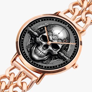 A rose gold wristwatch with a black face and a skull design. The skull is made of gears and other mechanical parts.