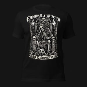 Emotionally Attached To 22 Strangers gothic football fan shirt featuring a frustrated skeleton sitting on a throne with a soccer ball, dark humor sports tee, gothic soccer shirt, vintage skeleton artwork, football lover gift, alternative fashion, dark academia style, soccer supporter apparel, unique football fan clothing, match day shirt, gothic sports design, unisex football t shirt.