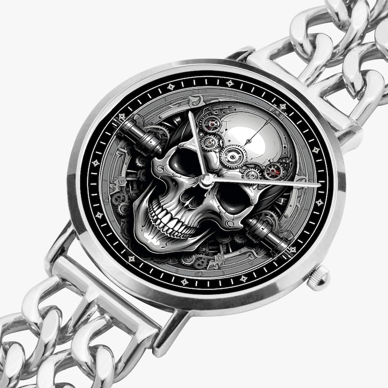 A silver wristwatch with a black face and a skull design. The skull is surrounded by gears and other mechanical elements. The watch has a silver chain link band.
