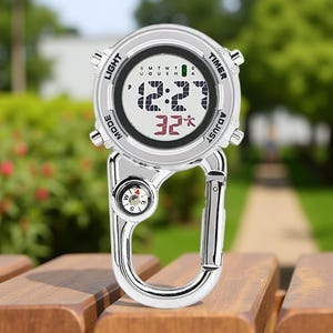 May include: A silver digital watch with a carabiner clip. The watch face displays the time and temperature. A small compass is integrated into the clip. The watch has buttons labelled "Light", "Mode", "Timer", and "Adjust".