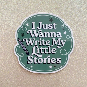May include: A green sticker with the text "I Just Wanna Write My Little Stories" in white, with a pencil illustration. The sticker has a decorative border and star accents.