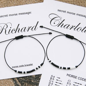 May include: Two black string bracelets with white beads spelling out the names "Richard" and "Charlotte" in Morse code. The bracelets are on a white background with the text "secret morse message" and a Morse code alphabet chart.