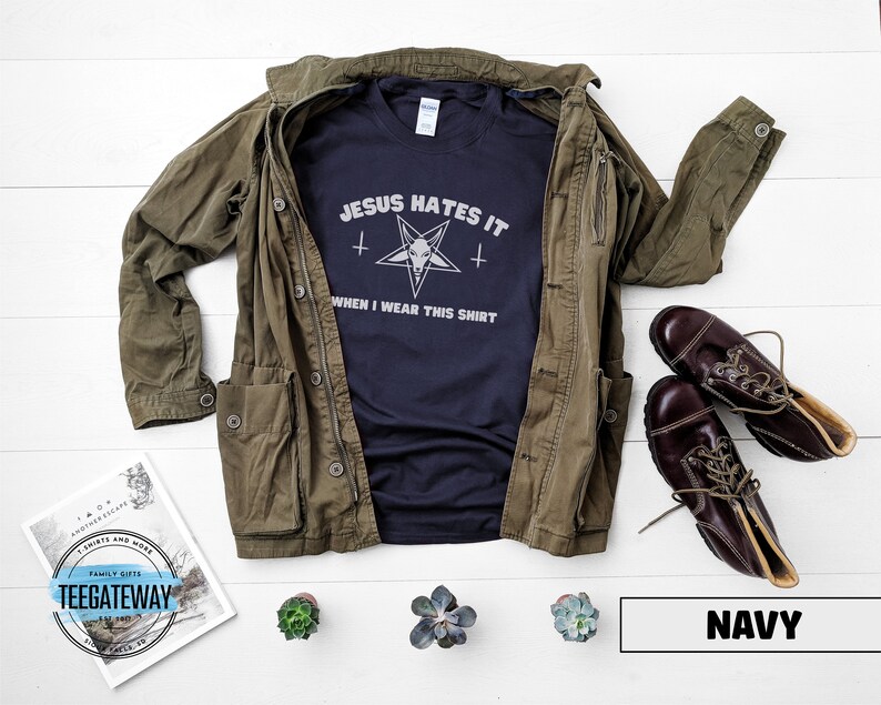 May include: A navy blue t-shirt with the text "Jesus Hates It" and a pentagram with a goat's head inside. The text below the pentagram reads "When I Wear This Shirt".