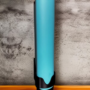 Op de afbeelding: Een lange, cilindrische waterfles in een levendige turquoise kleur, met een zwarte dop en een zwarte houder. De fles staat tegen een getextureerde grijze muur en een houten oppervlak.