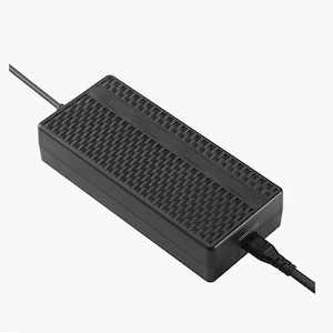 Pode incluir: Um adaptador de energia retangular preto com uma superf&iacute;cie texturizada e um cabo de alimenta&ccedil;&atilde;o que se estende de uma extremidade. O adaptador tem um padr&atilde;o de grade em sua superf&iacute;cie superior e uma porta para o cabo de alimenta&ccedil;&atilde;o.