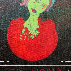 May include: A tarot card illustration of "The World." The card features a green-skinned figure with colorful hair and a red dress, holding a red orb. The card's title and Roman numeral "XXI" are displayed in red on a black background.