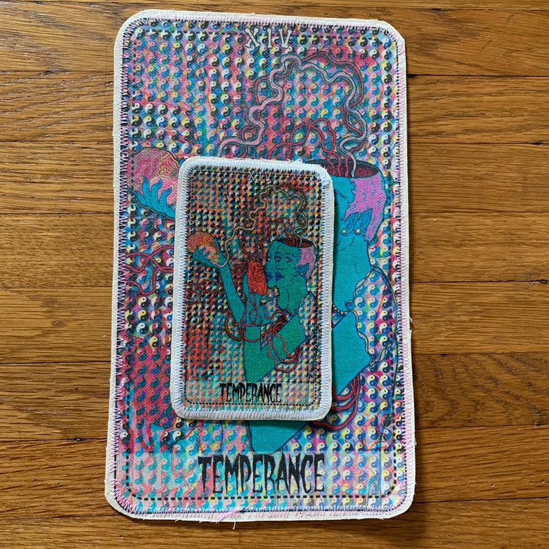 K&ouml;nnte beinhalten: Zwei aufgestickte Aufn&auml;her mit der Tarotkarte Temperance. Der gr&ouml;&szlig;ere Aufn&auml;her hat eine teal- und rosa Illustration mit dem Wort "Temperance" am unteren Rand. Der kleinere Aufn&auml;her befindet sich oben, mit der gleichen Illustration und dem gleichen Text. Der Hintergrund ist ein farbenfrohes Muster.