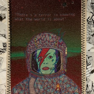 May include: A rectangular fabric patch featuring a colorful illustration of an astronaut with a lightning bolt on their face. The astronaut is wearing a helmet and spacesuit. The text "There's a terror in knowing what the world is about" is printed at the top.