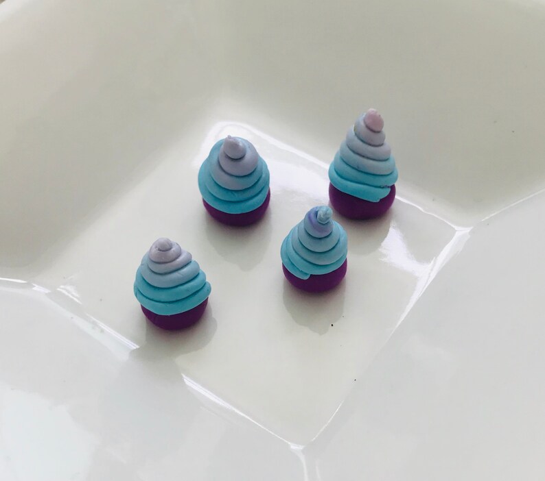 Pode incluir: Quatro pequenos ornamentos de argila feitos &agrave; m&atilde;o, de cor roxa e azul em espiral. Os ornamentos t&ecirc;m a forma de um cone e um padr&atilde;o de espiral de cor azul claro e roxo.