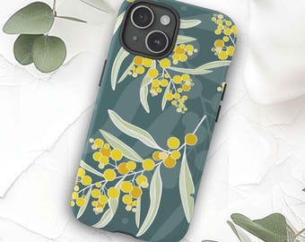 Puede incluir: Una funda para teléfono azul verdoso con un patrón floral de flores de acacia amarillas y hojas verdes. La funda está diseñada para un iPhone con una protuberancia de cámara. El texto "Australian Artist Design" está impreso en la parte superior de la imagen y "Printed in Australia" está impreso en la parte inferior.