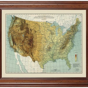 May include: A vintage map of the United States showing physical features, including elevation, rivers, and coastlines. The map is in a brown wooden frame. The title of the map is "Physical Features of the United States".