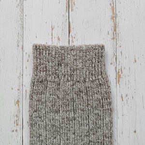 Brown Anna wool sock cuff detail on a white wooden rustic background