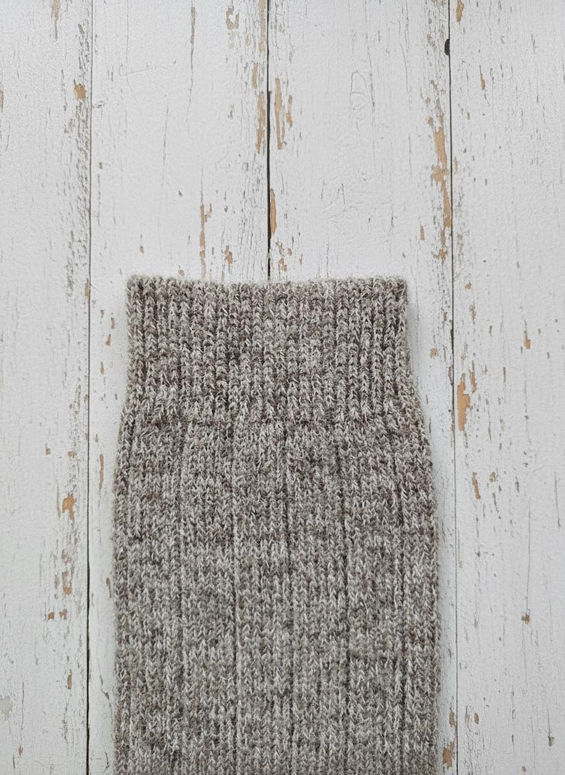 Brown Anna wool sock cuff detail on a white wooden rustic background