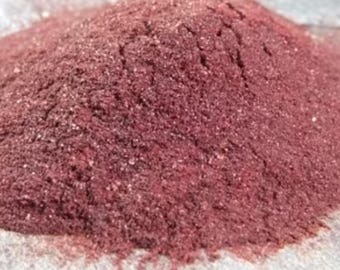 May include: A close-up of a pile of fine, reddish-brown powder. The powder has a slightly grainy texture and is evenly distributed.