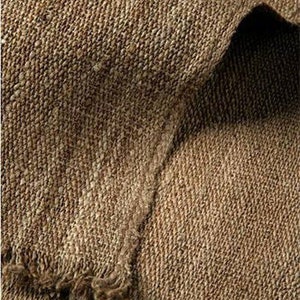 May include: Close-up of a brown woven fabric with a rough texture. The fabric has a subtle herringbone pattern and a frayed edge.