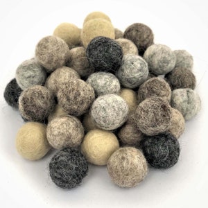 Peut inclure: Un tas de boules de feutre dans différentes nuances de brun, gris et beige. Les boules sont douces et moelleuses, et elles seraient parfaites pour un projet d'artisanat ou un accent décoratif.