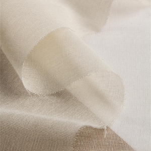 May include: Close-up of a white, sheer fabric with a fine mesh texture. The fabric is folded and draped, showing its delicate and airy quality.