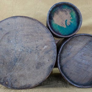 May include: Three wooden nesting boxes with lids. The largest box is brown and has a smooth surface. The middle box is brown and has a smooth surface. The smallest box is brown with a blue and green painted interior.