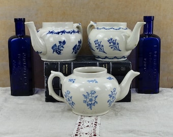 Trío de teteras antiguas de Saint Uze, de loza francesa con motivos florales azules.