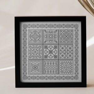 May include: A black framed picture with a white background and a black and white geometric design. The design is made up of nine squares, each with a different pattern.