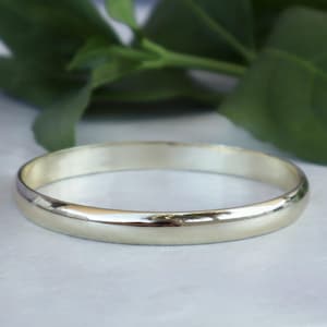 May include: A simple, polished silver wedding band.