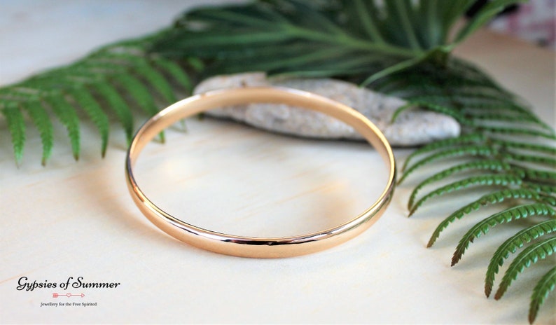 May include: A simple gold bangle bracelet, a classic piece of jewelry.