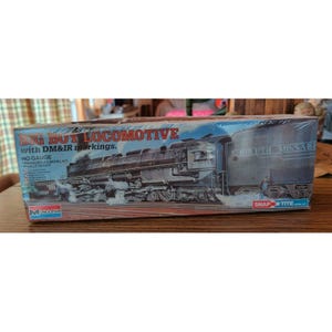 May include: A rectangular cardboard box for a Monogram Big Boy locomotive model kit in HO gauge. The box features a graphic illustration of a black steam locomotive with DM&IR markings, white smoke, and the text Snap Tite in the bottom corner.