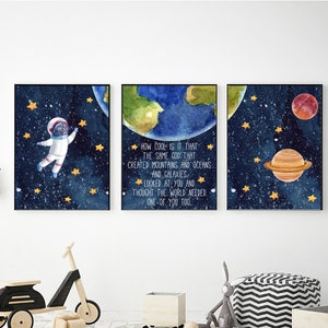 Op de afbeelding: Drie aquarellen met een ruimtethema. De eerste afbeelding toont een astronaut die in de ruimte zweeft met sterren en een planeet op de achtergrond. De tweede afbeelding toont een citaat over de schepping van de wereld. De derde afbeelding toont een planeet met ringen en een rode planeet op de achtergrond.