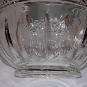 May include: A clear glass bowl with a fluted design and a wide, flat base.