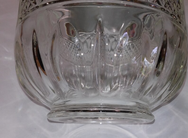 May include: A clear glass bowl with a fluted design and a wide, flat base.