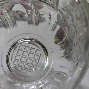 May include: A clear glass bowl with a grid pattern on the bottom. The bowl has a scalloped edge and is made of thick glass.