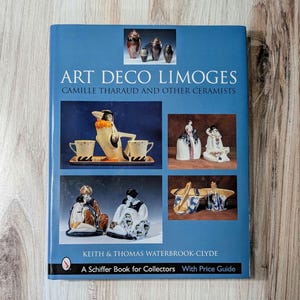Puede incluir: Portada de un libro con fondo azul y el título "Art Deco Limoges: Camille Tharaud y otros ceramistas". La portada incluye imágenes de varias piezas de cerámica, incluyendo un pingüino, una mujer con un vestido y un par de figuras.